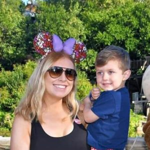 Colorful Disney-inspired Mickey Mouse ear headband with floral details and purple bow, perfect for amusement park visits.